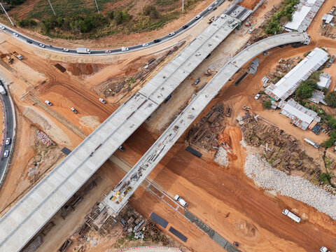The construction site before the construction of the concrete bridge over the intersection by crane workers, tractors, and backhoes