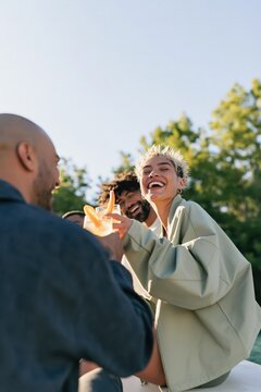 Laughing friends sharing drinks outside in daylight for summer social banner and lifestyle background design
