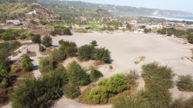 Aerial View of Gumuk Pasir Parangkusumo Sand Dunes with Coastal Village and Hills in Yogyakarta, Indonesia