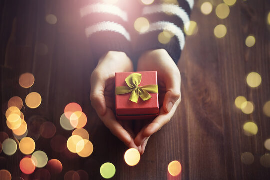 Male female hands holding gift box for birthday on wooden background. Fathers day valentine day, Christmas, New Year. Congratulations background.