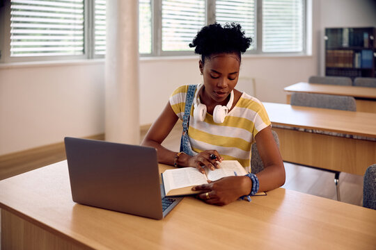 Black female college student studying in library.