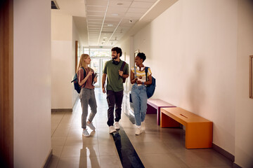 Multiracial group of happy students communicating at university.