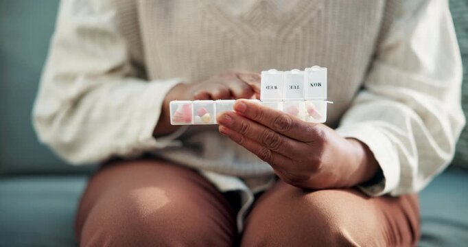 Woman, hands and pills with container on couch for medication, prescription or daily dosage in home. Female person, patient or sorting tablets for weekly pharmaceuticals, medical plan or treatment
