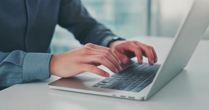 Professional employee typing on modern silver laptop computer in office