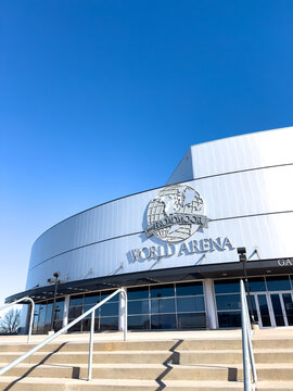 Modern arena building exterior under clear blue sky