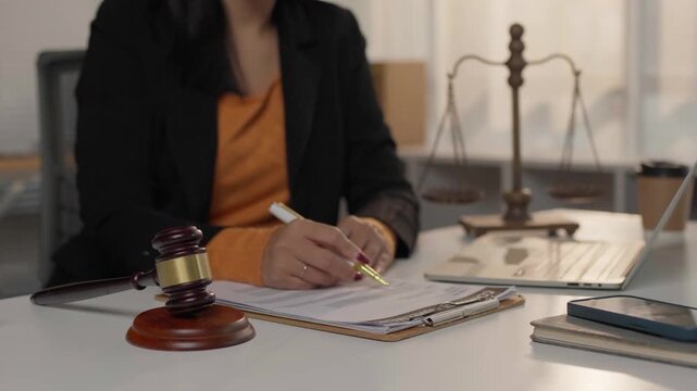Female lawyer signing legal document at desk
