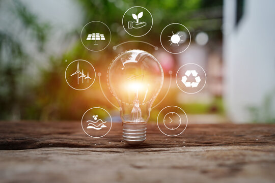 Light Bulb on Wooden Table with Green Energy and Environmental Icons