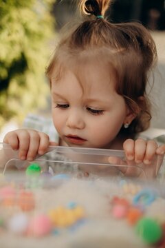 Curious toddler observing sensory materials in rice sensory bin