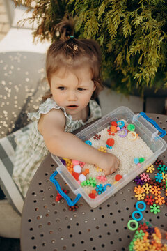 Focused toddler exploring textures in sensory rice activity