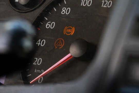Car speedometer needle rests near forty while ABS and warning indicators glow on the dark dial offering a focused view of instrument panel details and safe driving awareness