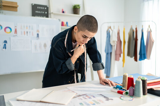 Caucasian young woman working as fashion designer in tailor studio. 