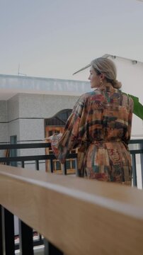 Elegant woman wearing luxury kimono robe in modern tropical home.
