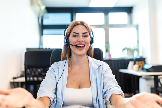 Customer support call center agent. Happy customer service operator wearing headset, Smiling woman working at office desk and welcoming client. Professional helpline representative.