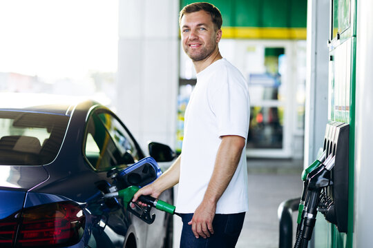 Man filling up car with gasoline at a fuel station, showing everyday task of vehicle maintenance and energy needs