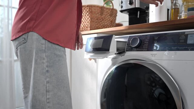 A close-up image of a woman adding laundry detergent to a washing machine. The image illustrates concepts related to fabric care, house cleaning, and garment maintenance