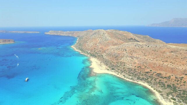Stunning high angle drone shot capturing the rocky ridge of Gramvousa peninsula and vibrant turquoise waters of Balos cape in Crete, Greece. Beautiful Mediterranean wilderness landscape, daytime.