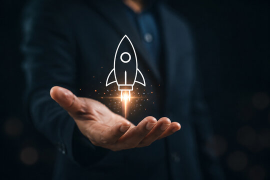 Startup business concept, Businessman holding rocket icon on virtual screen for fast start up business. Strategic planning and business success. 