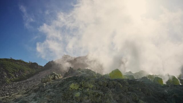Volcanic gas and steam rising from fumaroles on Mount Io in Akan Mashu National Park, Hokkaido, Japan, showcasing geothermal activity and yellow sulfur deposits on the rocky slopes