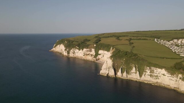 aerial shot of the White Cliffs of Seaton with the drone revealing winding coastal paths. Cinematic landscape captures the untouched beauty of the Jurassic Coast and its remarkable natural features.
