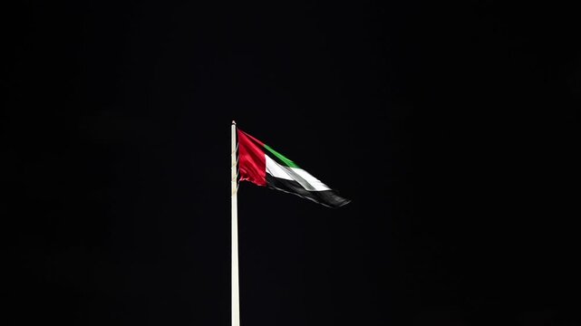 The UAE national flag proudly waving in the evening breeze.