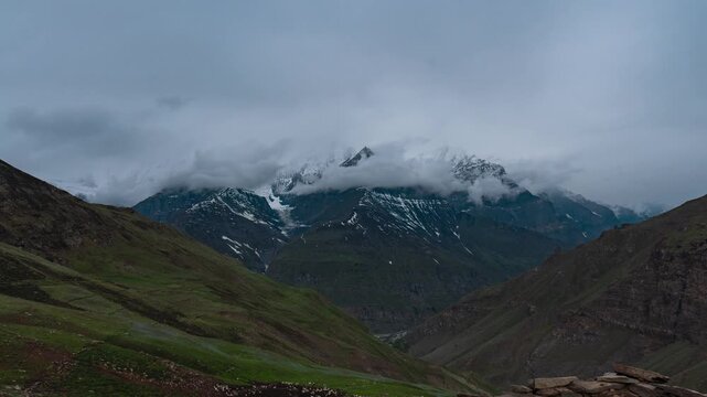 4K Timelapse of dark clouds moving above snowy mountain peak as seen from Ghepan Lake trek in Lahaul, Himachal Pradesh, India. Stormy weather time-lapse in Himalayas. Monsoon landscape. Nature backgro