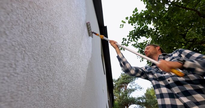 house painter restore paint on building exterior with roller