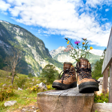 Hiking Boots Resting on a Wooden Bench in the Mountains on a Summer Day