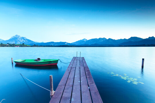 Scenic Alpine Lake with a Rustic Wooden Dock and old fishing boat