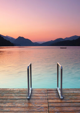 calm sunrise at the lake in the mountains, wooden jetty