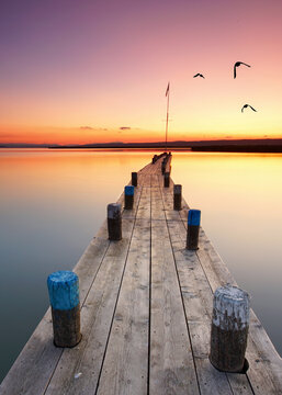 sunset on the pier with lighthouse in summer