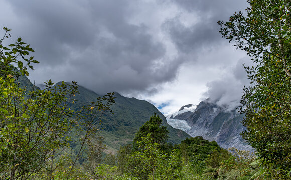 Franz Josef Glacier, Kā Roimata o Hine Hukatere, Gletscherzunge im Talkessel, Suedliche Alpen, Suedinsel, Neuseeland, Regenwald im Vordergrund, tief haengende Wolken