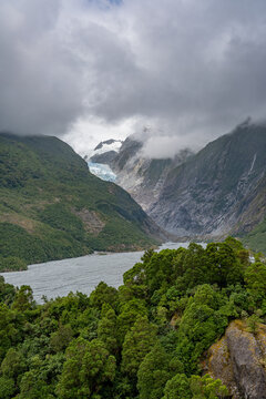 Franz Josef Glacier, Kā Roimata o Hine Hukatere, Gletscherzunge im Talkessel, Suedliche Alpen, Suedinsel, Neuseeland, Regenwald im Vordergrund, tief haengende Wolken