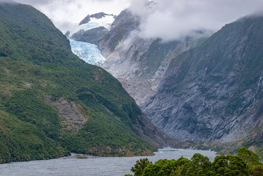Franz Josef Glacier, Kā Roimata o Hine Hukatere, Gletscherzunge im Talkessel, Suedliche Alpen, Suedinsel, Neuseeland, Regenwald im Vordergrund, tief haengende Wolken