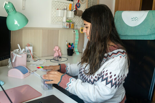 A white woman organizes items on her desk