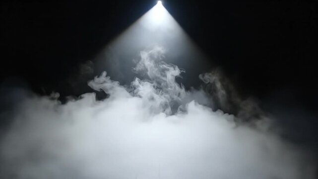 Single bright spotlight illuminating a dark stage floor with swirling white smoke and haze