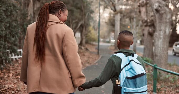 Mom, walk and holding hands outdoor with school child, connection and support for education goals. Back, happy black woman and son in neighborhood with safety, bonding together or commute to academy.