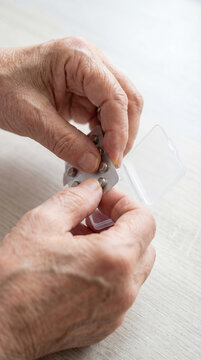 Close view of senior hands removing medication tablet from blister pack, authentic active aging concept showing independence confidence value value value value value value value value