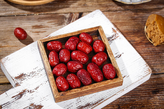 High Quality Dried Red Jujube Dates from Ruoqiang Xinjiang in Wooden Box on Rustic Wood Table