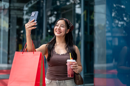 Asian Woman Taking Selfie with Smartphone while Shopping