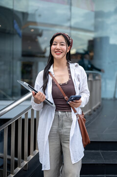Portrait of Smiling Asian Woman Holding Laptop and Smartphone