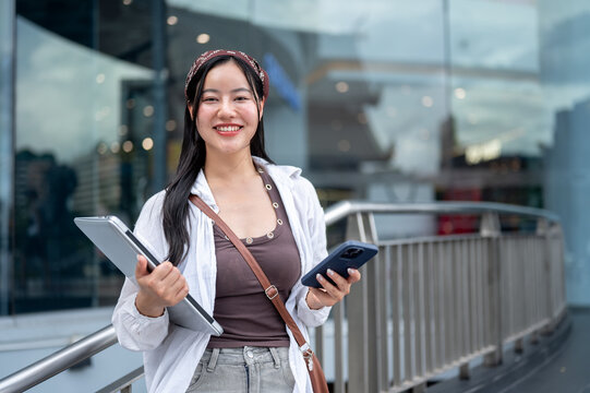Portrait of Young Asian Businesswoman Holding Laptop and Phone