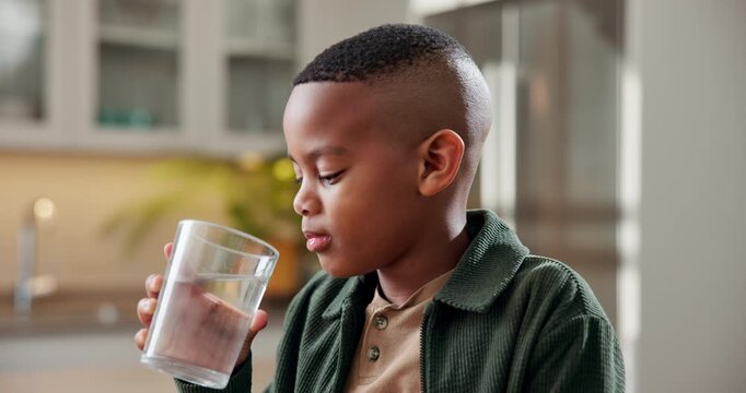 Health, kid and drinking water in home for wellness, nutrition benefits and development for growth. Thirsty black child, hydration or glass with beverage for diet, minerals and refreshment at kitchen