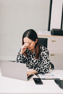 Tried young Asian office employee feeling sick and have a headache from a long working day at office