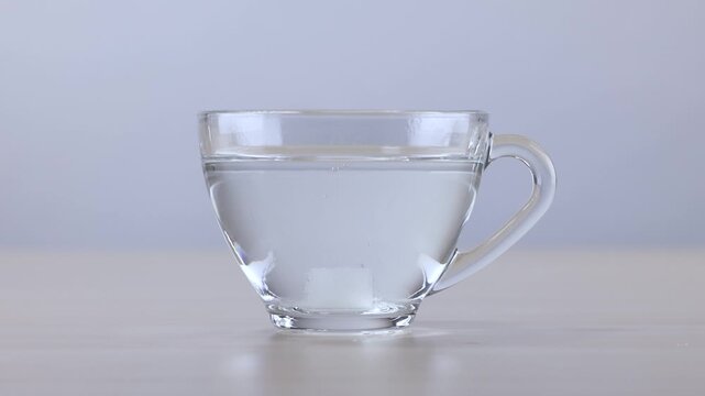 Sugar Cube Dissolving in a Glass Cup of Hot Water