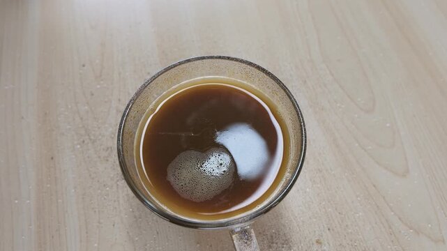 Top View of Sugar Pouring into a Glass Coffee Mug
