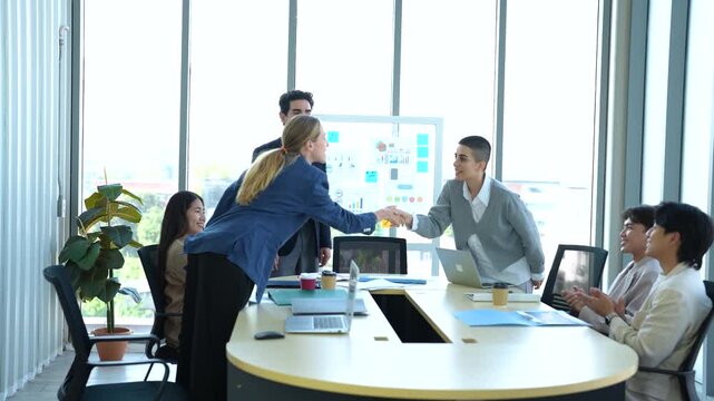 Business team meeting in modern office with manager presenting performance reports. college congreted with female team member by shake hands and crap hands.