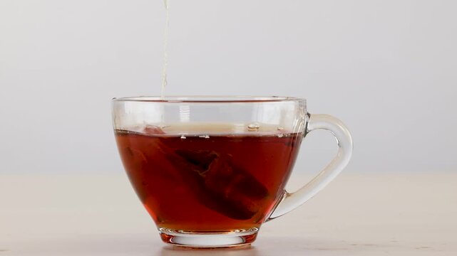 Herbal Tea Bag Steeping and Being Removed from Glass Cup