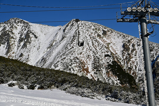 View of the cable car in line with the forest and snowy meadows 