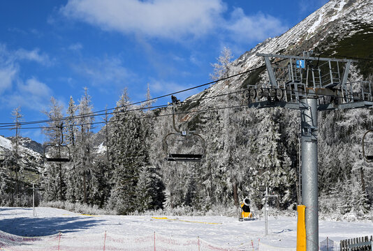 View of the chairlift in the background with snow-capped mountain peaks