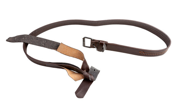 A worn brown leather belt with a dark metal buckle lies twisted on a plain white background.